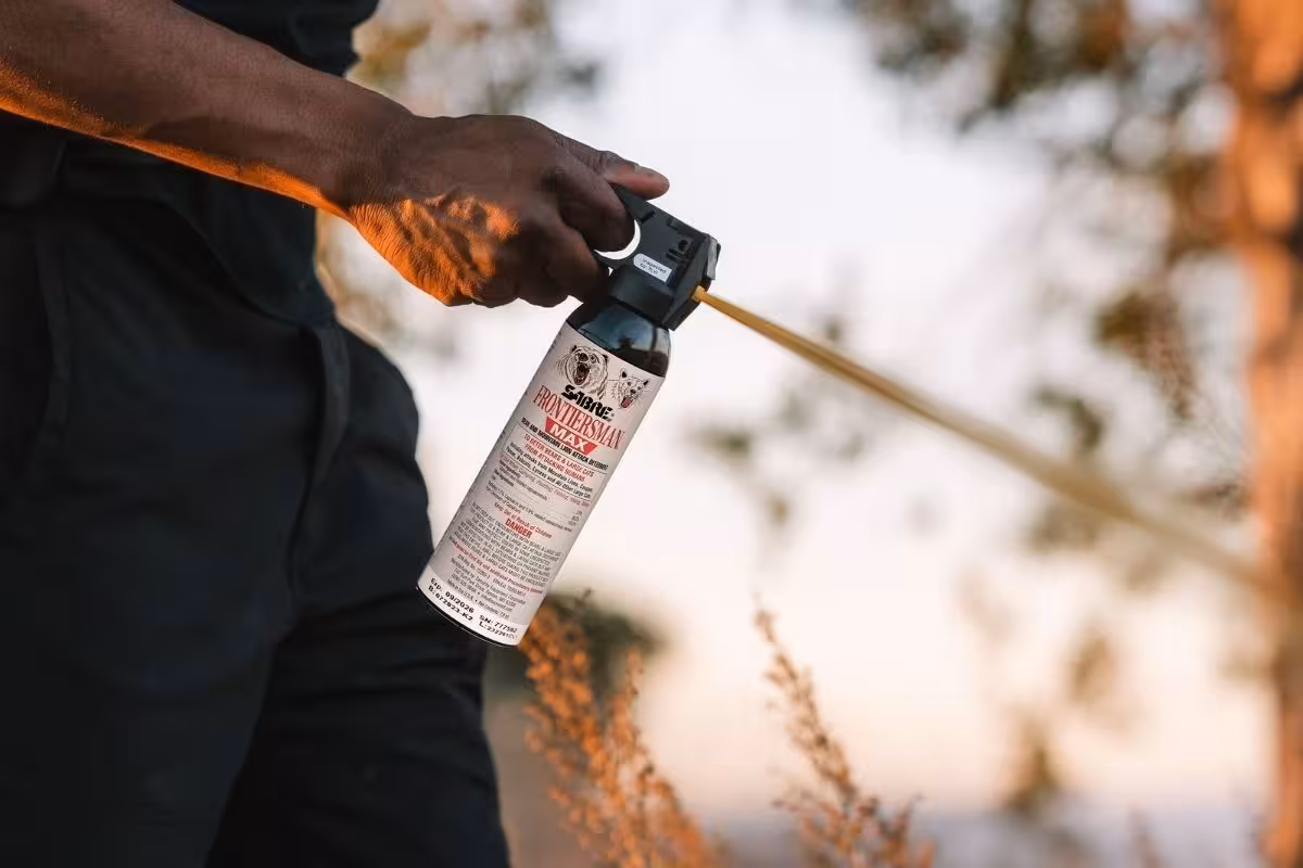 A person spraying SABRE brand bear spray