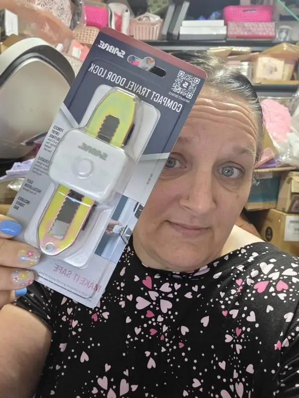 A person holding a SABRE compact travel door lock