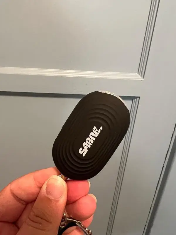 A person holding a SABRE personal alarm with LED flashlight