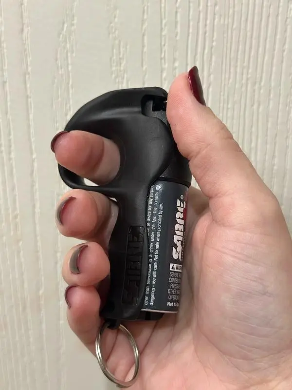 A woman holding a SABRE quick grip spray
